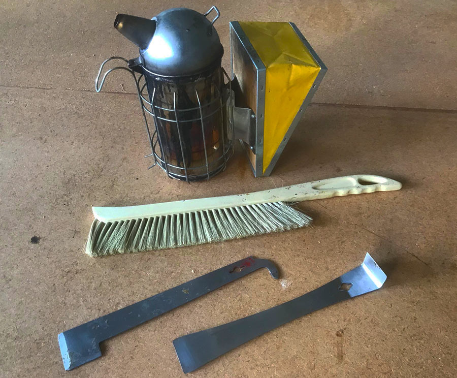 A bee smoker, bee brush and hive tools